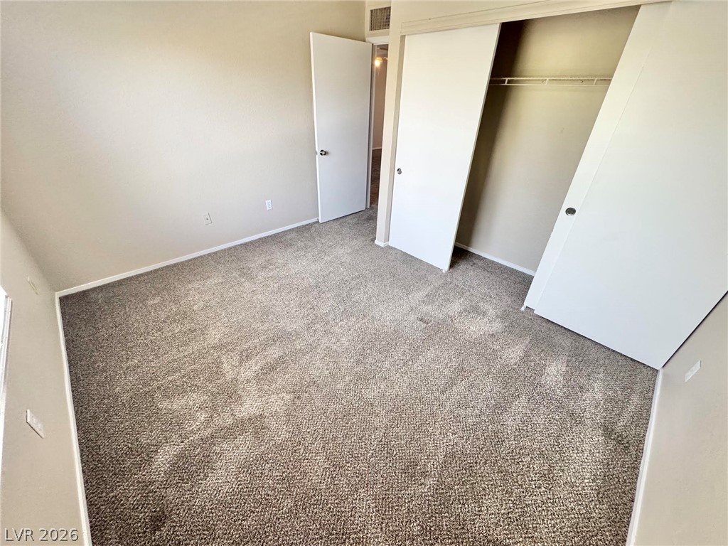 8070 West Russell Road, Unit 2121 Las Vegas, NV 89113 - Photo 9 of 22 A well-maintained carpeted bedroom with a spacious closet ready for personalization.