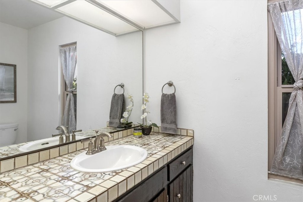3240 Skycrest Drive Fallbrook, CA 92028 - Photo 23 of 40 a bathroom with a granite countertop sink and a mirror