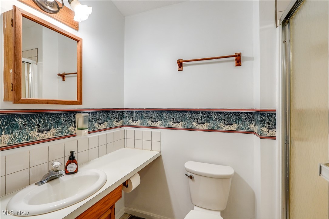 10461 Wye Road Chesterland, OH 44026 - Photo 43 of 50 Bathroom featuring backsplash, a shower with shower door, toilet, and vanity