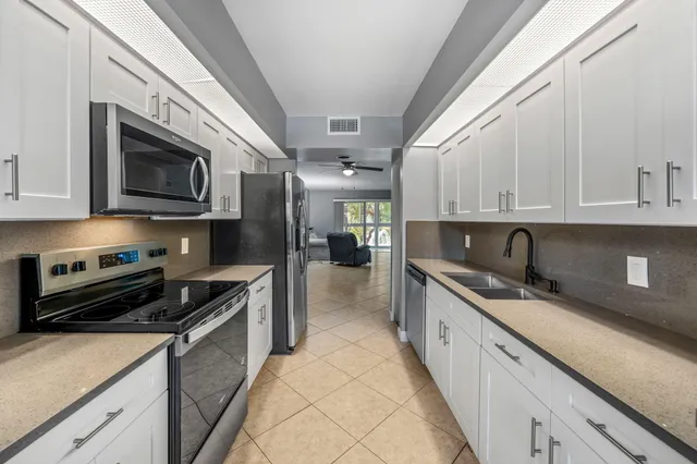 a kitchen with stainless steel appliances granite countertop a sink and stove top oven