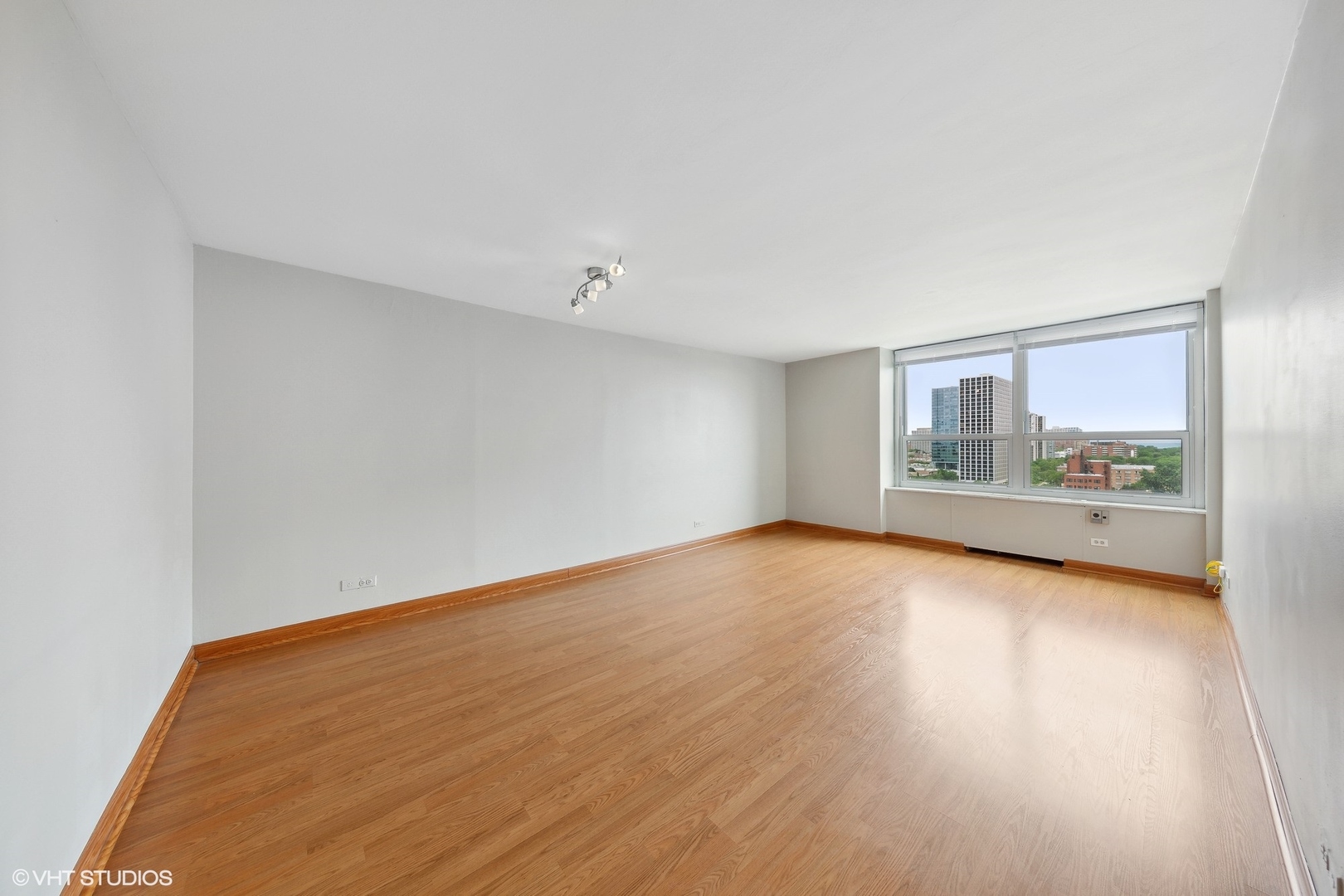 720 West Gordon Terrace, Unit 14F Chicago, IL 60613 - Photo 13 of 17 a view of an empty room with wooden floor and a window
