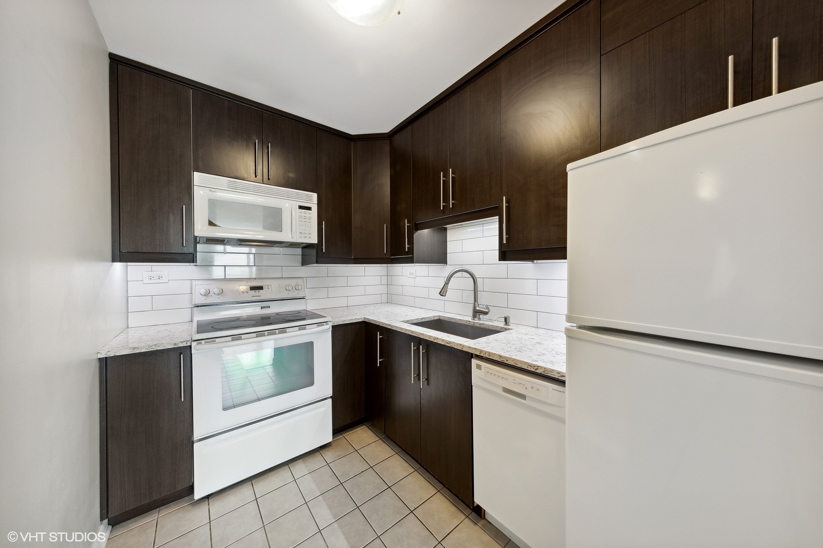 720 West Gordon Terrace, Unit 14F Chicago, IL 60613 - Photo 5 of 17 a kitchen with stainless steel appliances granite countertop a sink and a stove