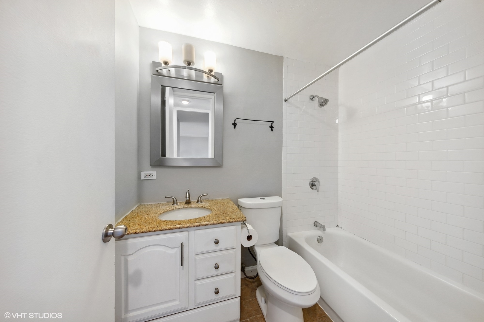 720 West Gordon Terrace, Unit 14F Chicago, IL 60613 - Photo 9 of 17 a bathroom with a granite countertop toilet sink and mirror