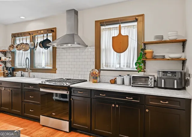 a kitchen with a sink and a stove with wooden floor
