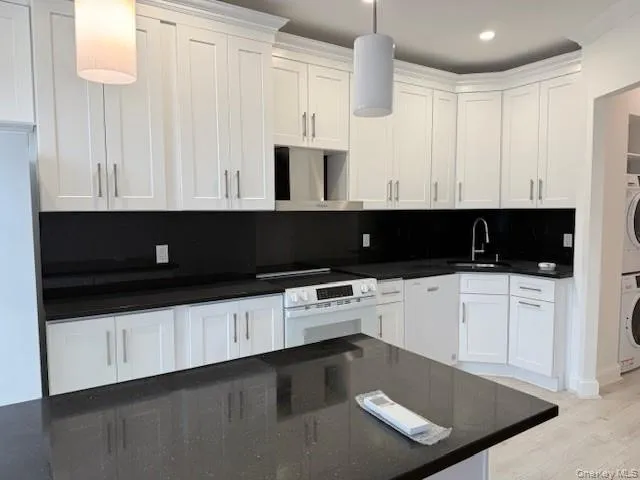 a kitchen with granite countertop white cabinets and black appliances