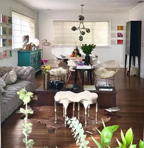 a living room with furniture dining table and a chandelier