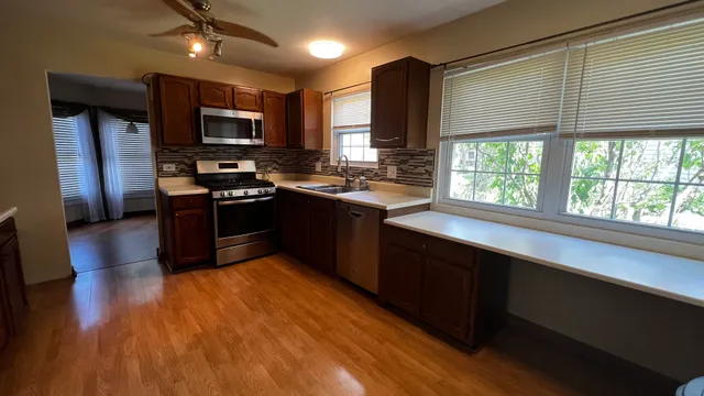 a kitchen with stainless steel appliances granite countertop a stove a sink and a microwave