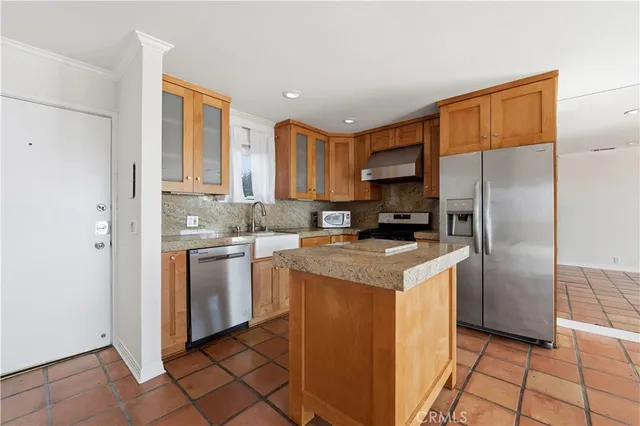 a kitchen with a refrigerator sink and cabinets