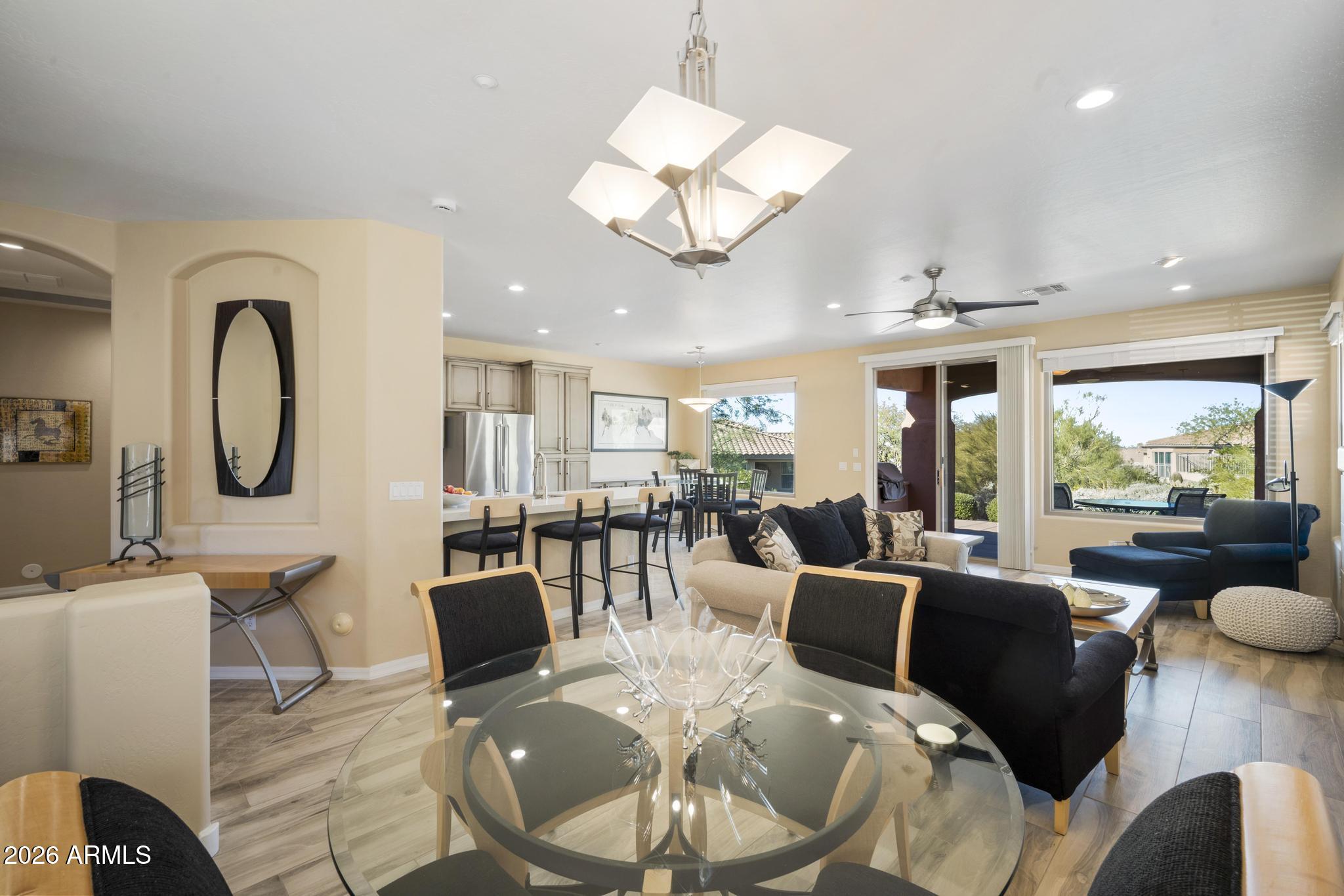 11448 East Raintree Drive Scottsdale, AZ 85255 - Photo 11 of 37 a living room with furniture a large window and a dining table