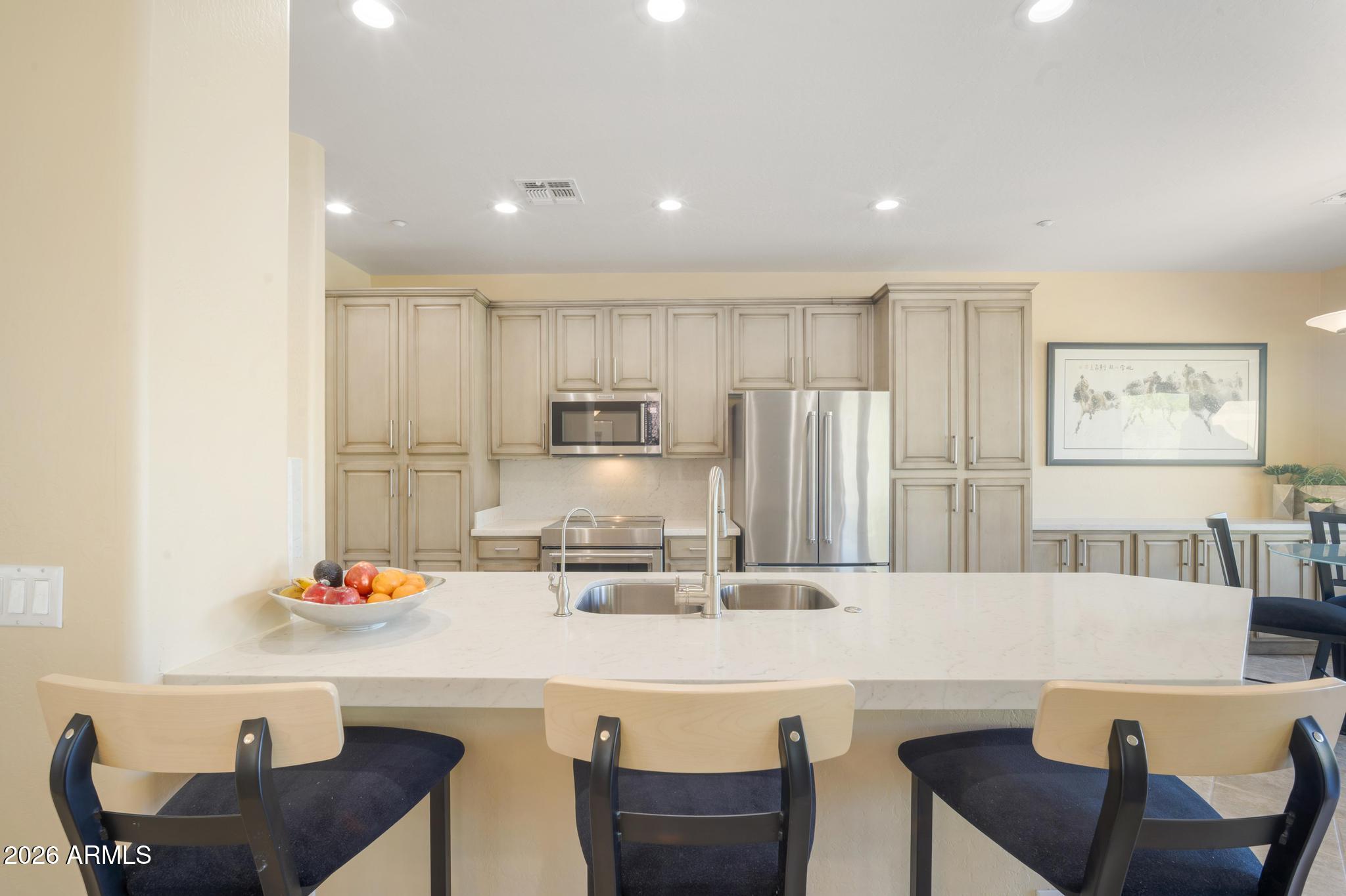 11448 East Raintree Drive Scottsdale, AZ 85255 - Photo 2 of 37 a kitchen with stainless steel appliances kitchen island granite countertop a kitchen island and chairs in it