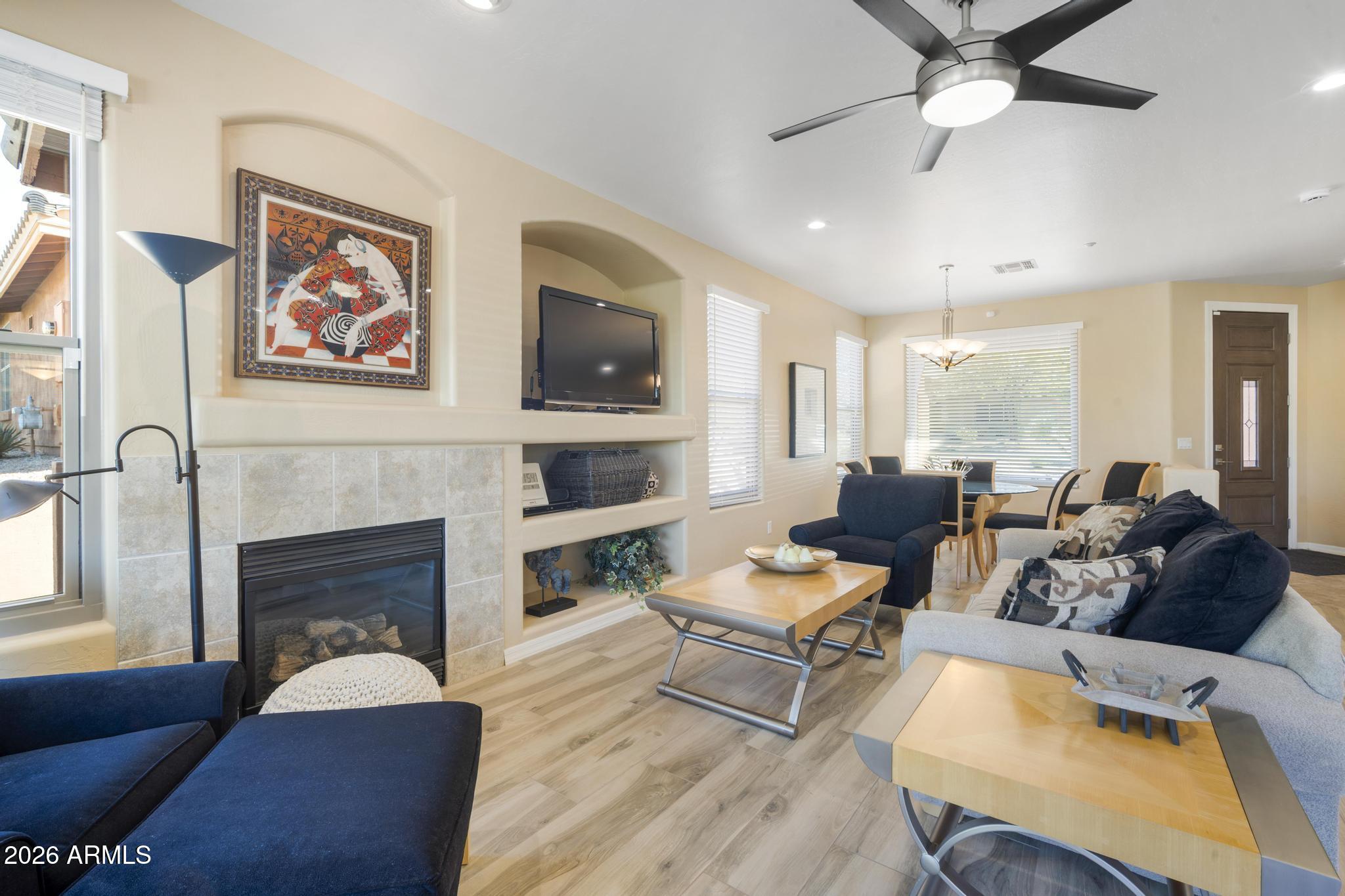 11448 East Raintree Drive Scottsdale, AZ 85255 - Photo 8 of 37 a living room with furniture a fireplace and a flat screen tv