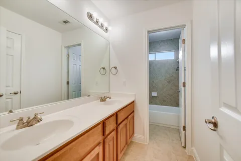 a bathroom with a granite countertop sink and a mirror a bathtub