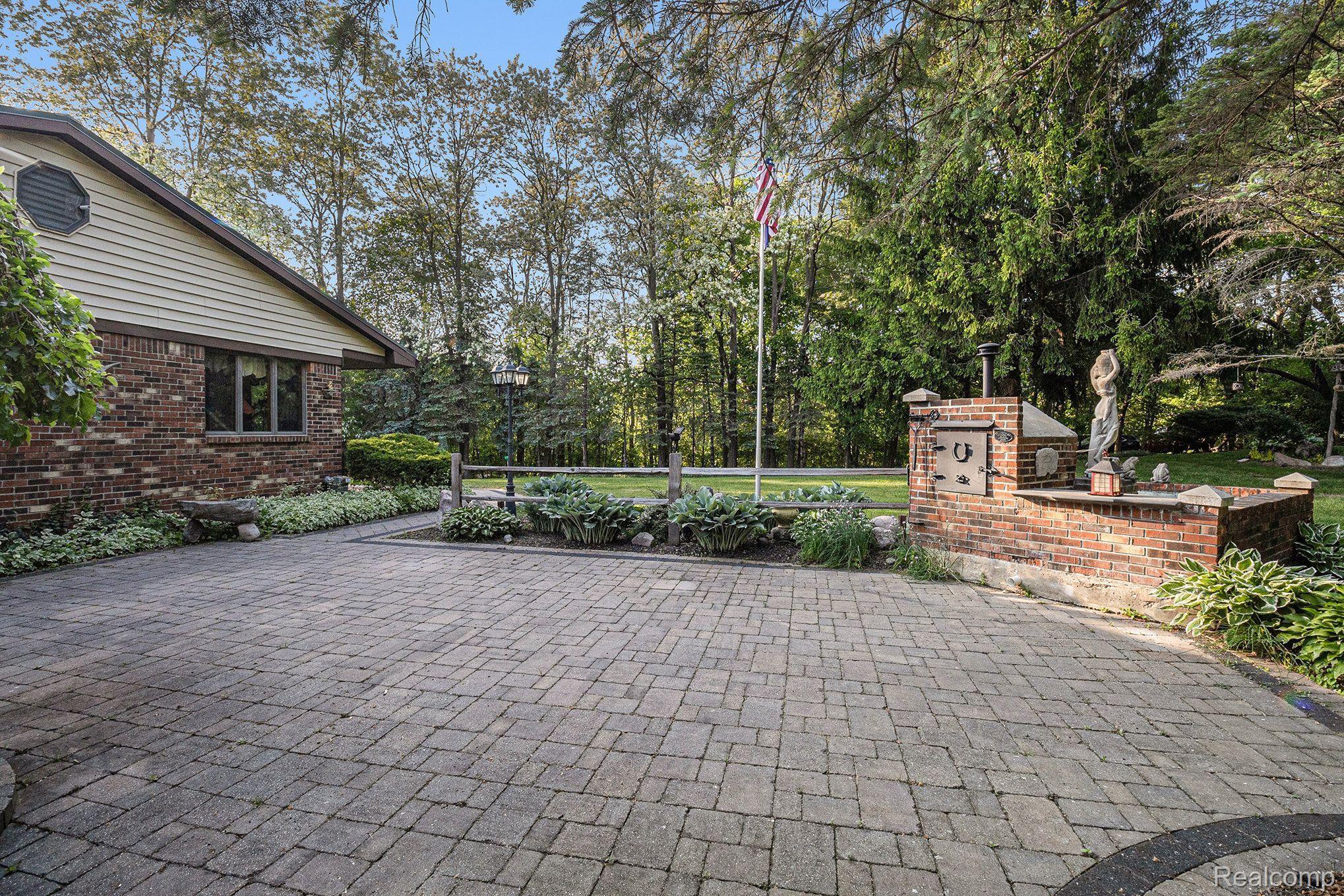 7280 Groveland Road Holly, MI 48442 - Photo 28 of 48 brick patio, pizza oven, and fountain