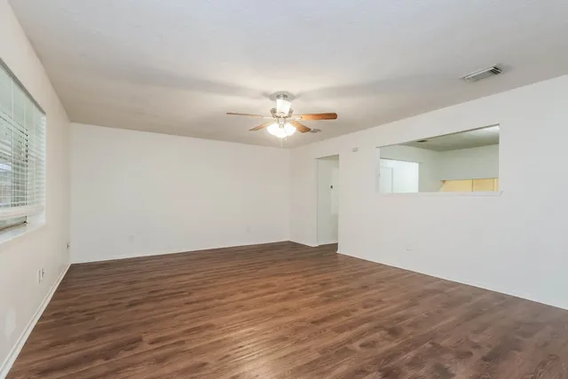 a view of an empty room with a chandelier fan