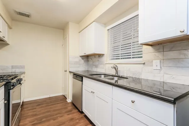 a kitchen with granite countertop a sink and a stove