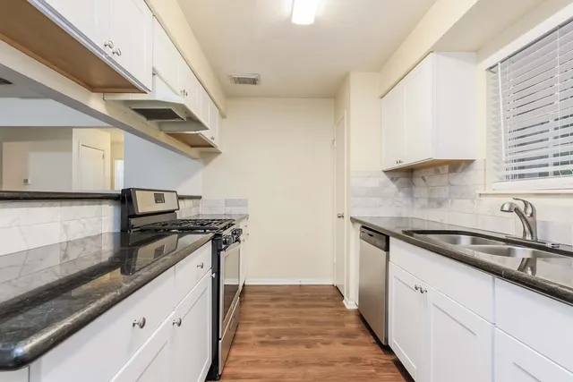a kitchen with stainless steel appliances granite countertop a sink and a stove