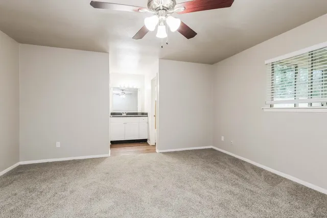 a view of a room with a ceiling fan and a window