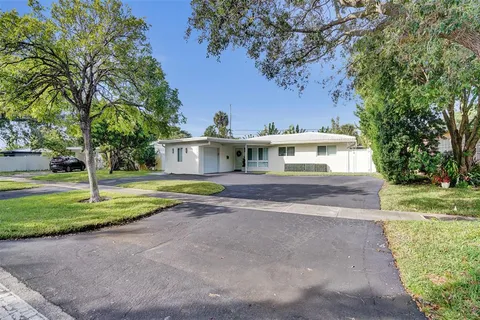a front view of a house with a yard and trees