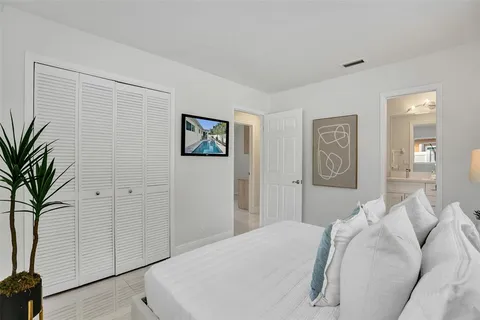 a bedroom with a large bed and a potted plant