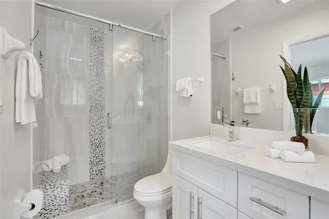 a bathroom with a sink toilet double vanity and shower