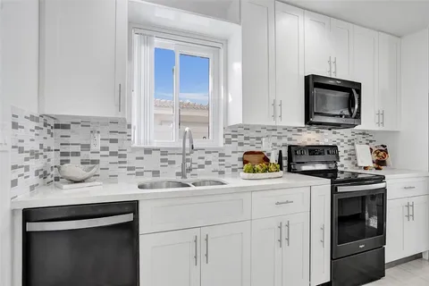 a kitchen with stainless steel appliances granite countertop a sink stove a microwave and cabinets