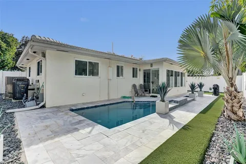 a view of a house with swimming pool and sitting area