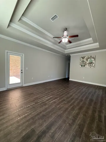 a view of an empty room with window and wooden floor
