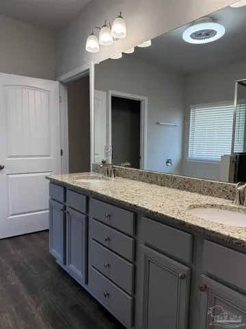 a bathroom with a granite countertop double vanity sink and a mirror