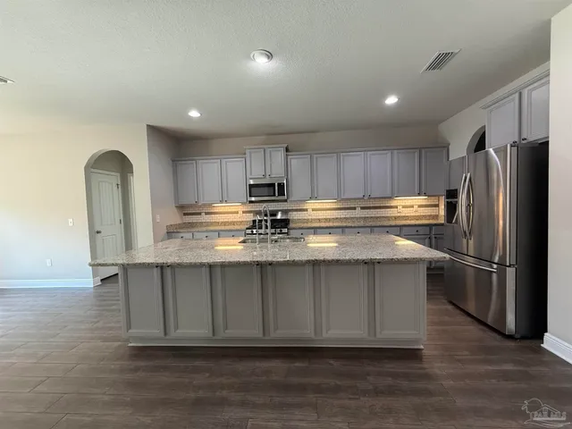 a kitchen with stainless steel appliances granite countertop a refrigerator sink and cabinets