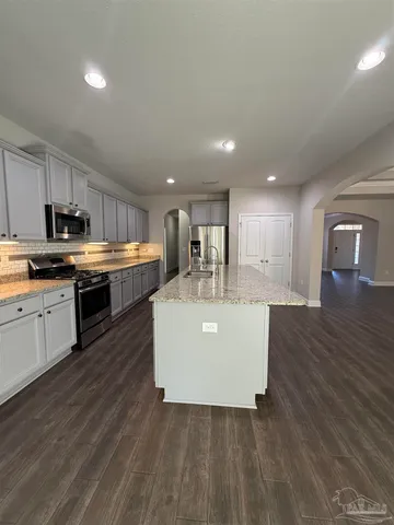 a view of kitchen with kitchen island stainless steel appliances sink refrigerator and stove