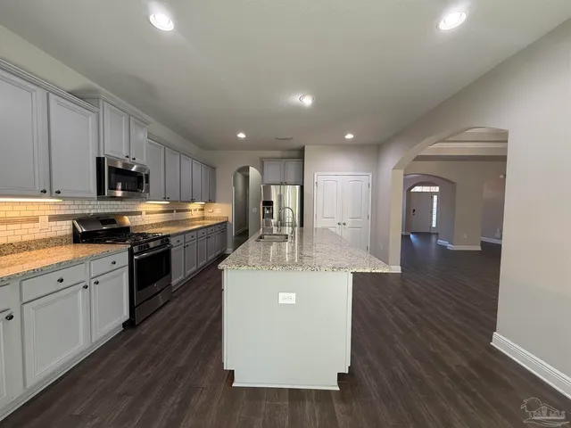 a kitchen with kitchen island white cabinets and stainless steel appliances