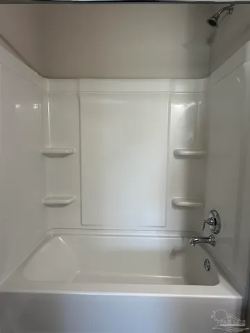 a bathroom with a granite countertop sink a toilet a mirror and bathtub