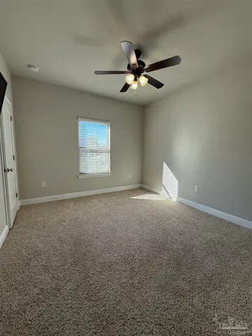 a view of an empty room with a ceiling fan