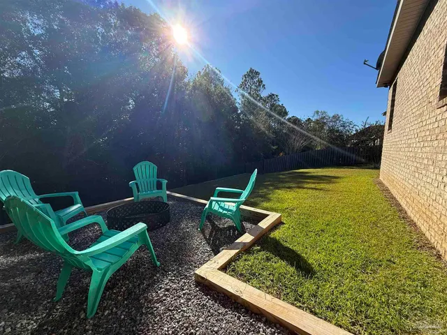 a backyard of a house with plants and large trees