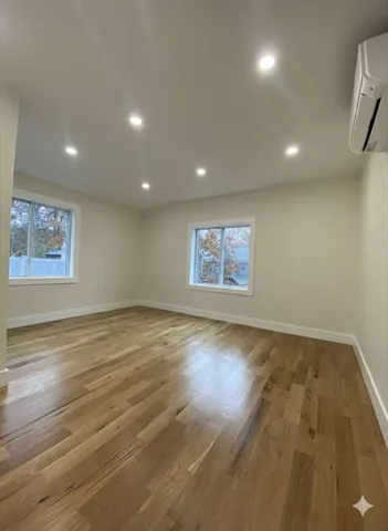 an empty room with kitchen view and a flat screen tv