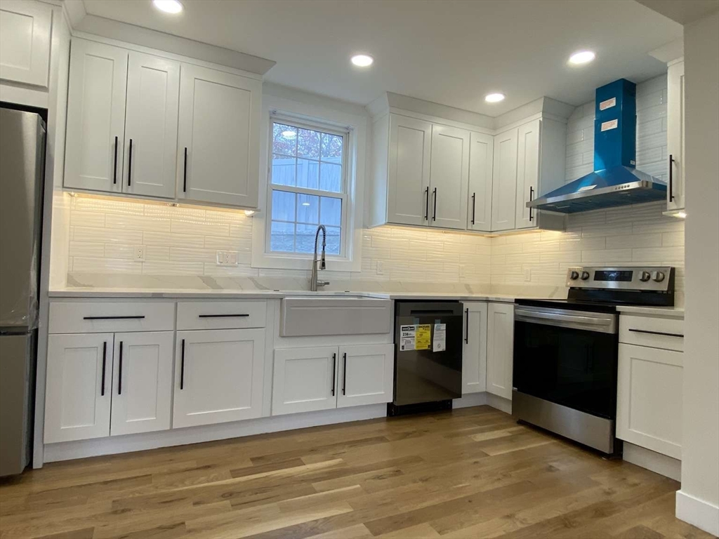 30 Russell Road, Unit 30 Chelmsford, MA 01863 - Photo 10 of 20 a kitchen with kitchen island granite countertop a stove and a sink