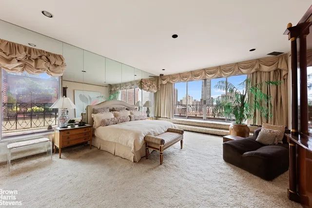 a spacious bedroom with a bed couch and a large window