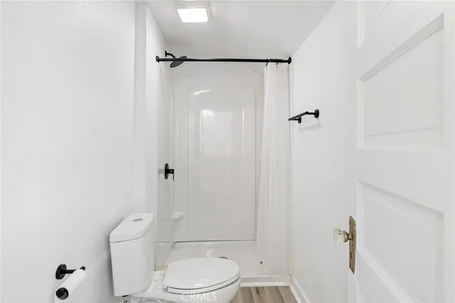 a bathroom with a toilet and a shower