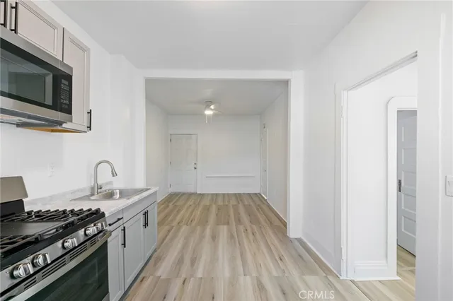 a kitchen with granite countertop stainless steel appliances a sink cabinets and a stove top oven