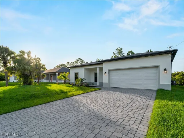 an aerial view of residential houses with outdoor space and parking