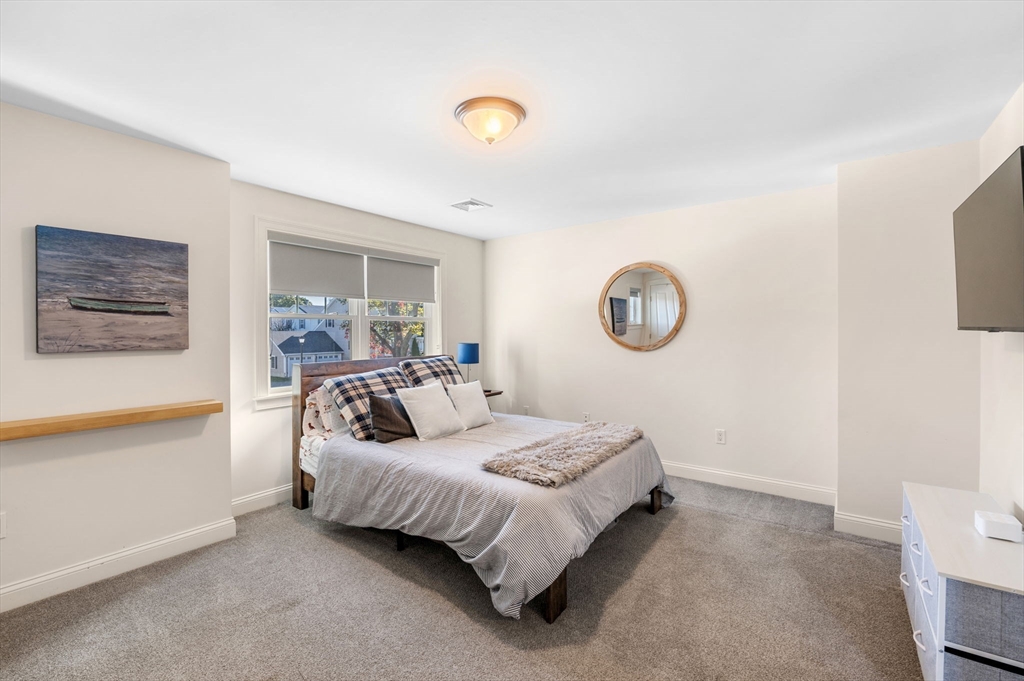 2-4 Gracie Lane, Unit 4 Swampscott, MA 01907 - Photo 22 of 37 a bedroom with a bed and a lamp on the dresser