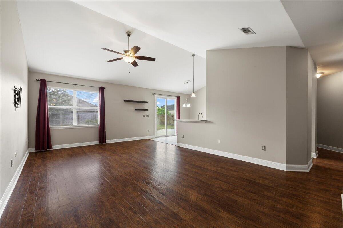 3629 Topaz Circle Navarre, FL 32566 - Photo 15 of 28 an empty room with wooden floor ceiling fan and windows