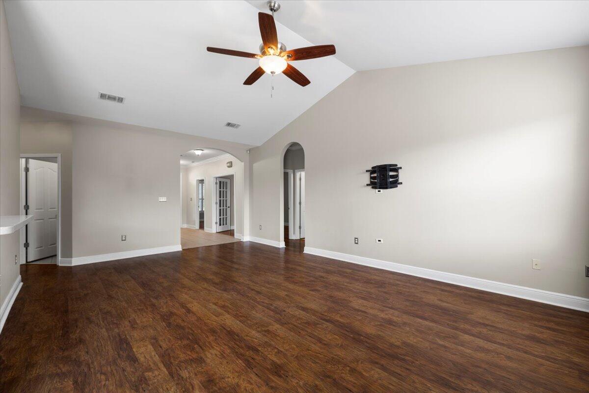 3629 Topaz Circle Navarre, FL 32566 - Photo 16 of 28 an empty room with wooden floor ceiling fan and windows