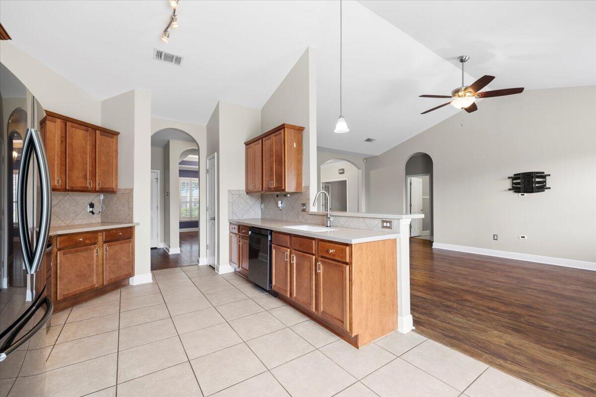 3629 Topaz Circle Navarre, FL 32566 - Photo 18 of 28 a large kitchen with stainless steel appliances granite countertop a refrigerator a sink dishwasher a stove with wooden cabinets and floor
