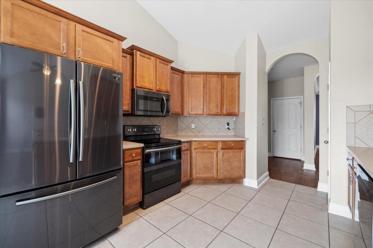 3629 Topaz Circle Navarre, FL 32566 - Photo 19 of 28 a kitchen with granite countertop a refrigerator and a stove top oven