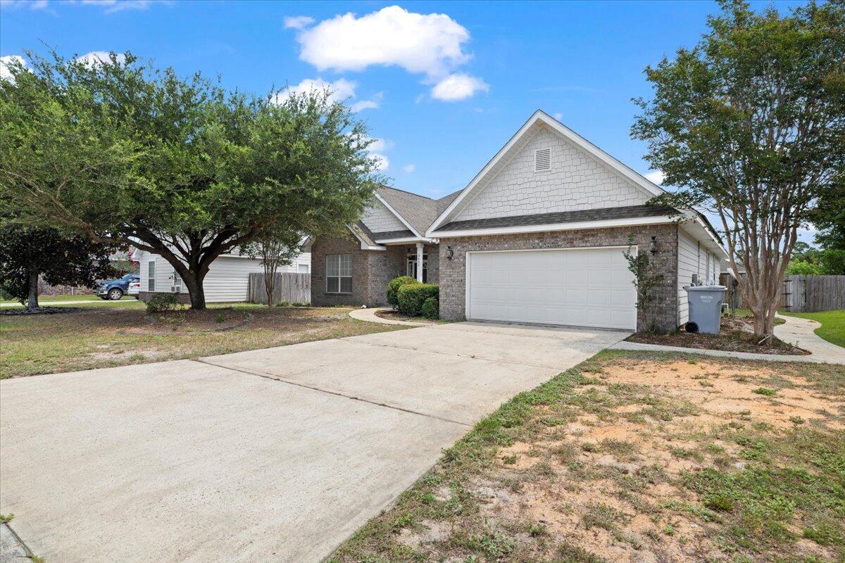 3629 Topaz Circle Navarre, FL 32566 - Photo 2 of 28 a view of garage yard and tree