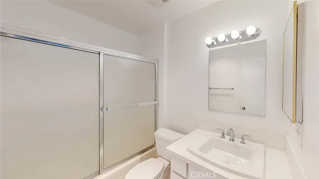 a view of an empty room with closet and a window