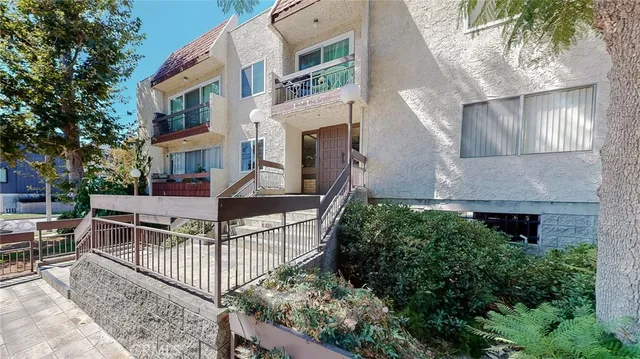 a view of house with wooden deck and furniture