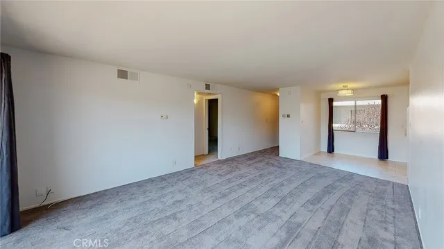 an empty room with windows and city view