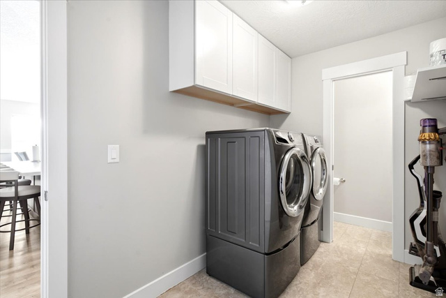 2973 West Red Sand Rd Haven Ogden, UT 84401 - Photo 16 of 30 Dedicated laundry area featuring light gray walls, white baseboards, and white overhead cabinetry with a wood-finish underside